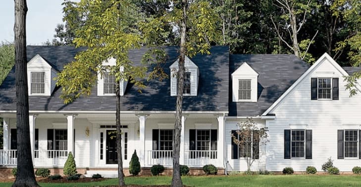 Gentek Siding being showcased on a white home, with trees scattered around.