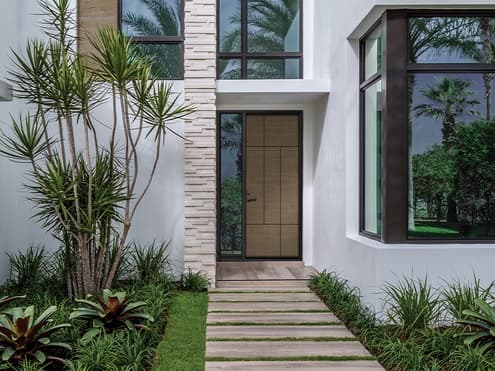 A Entry door being showcased with beautiful landscaping.