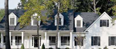 Gentek Siding being showcased on a white home, with trees scattered around.
