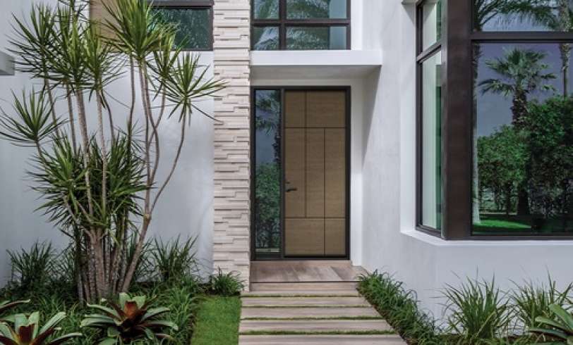 A Entry door being showcased with beautiful landscaping.